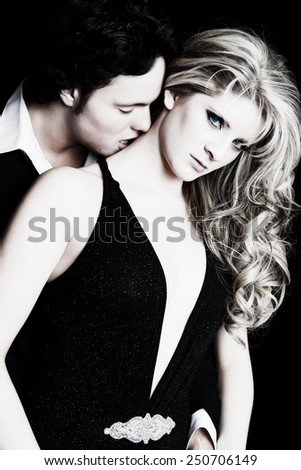 A young man seducing his beautiful girlfriend.  Formal wear fashion.