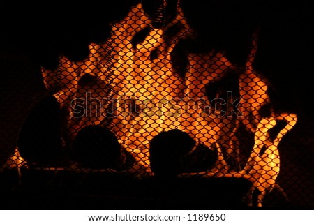 Fireplace Warmth.  Flames burn furiously behind the protective fireplace screen.