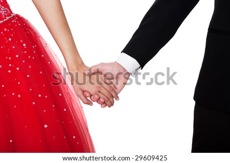 Boy & girl, in formal attire, holding hands against a white background.