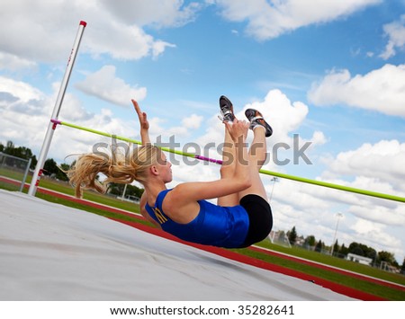 A young, athlete clearing the bar during a high jump event, in track and field.