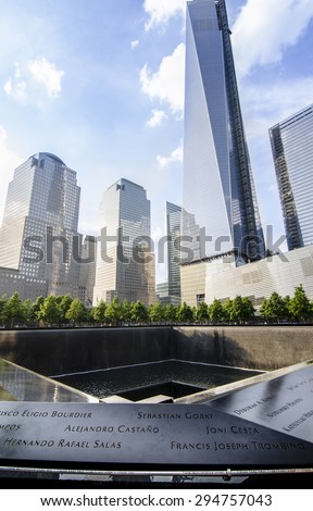 NEW YORK CITY, USA - MAY 30, 2013: Ground level view of the 9/11 memorial which includes one of the two waterfalls and names of the victims in the foreground, and new towers behind.