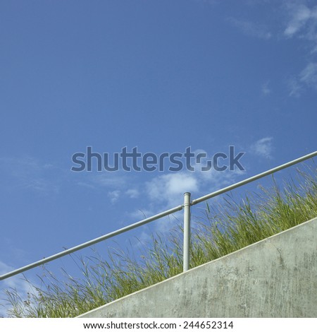 Industrial hand rail with grass and blue sky