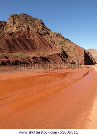 Red mountain and red road under blue sky from Andes Mendoza Argentina
