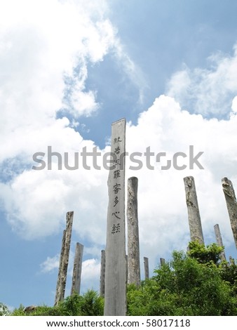 Wisdom Path of Heart Sutra - Chinese prayer on trunks under blue sky from Lantau Island country park, Hong Kong, China