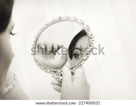 woman  bride looking in the mirror, vintage style image