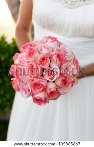 Bride holding a pink rose wedding bouquet.