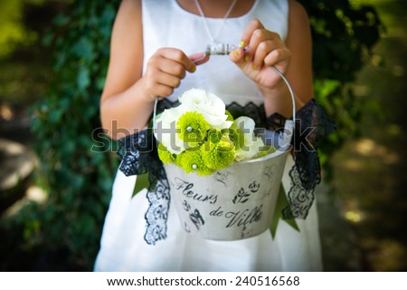 Flower girl at a wedding holding a basket of flowers.