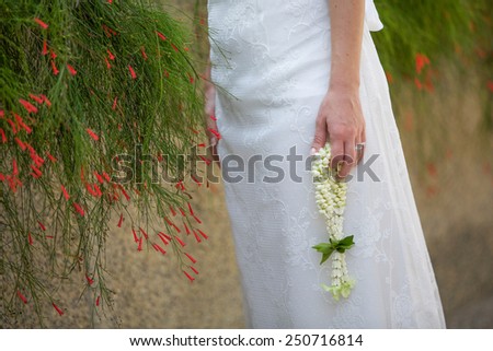 Bride holding a Thai wedding garland.