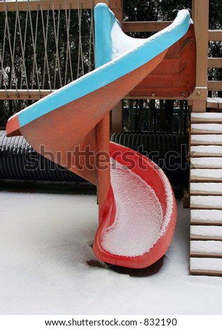 Blue and red slide covered in snow in a playground