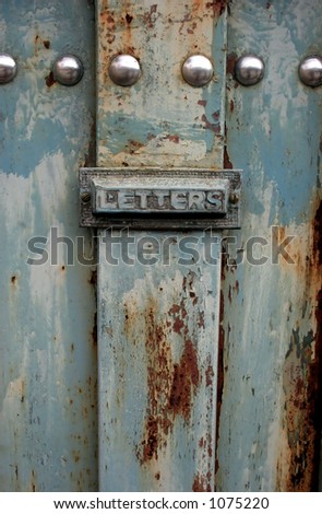 Old rusty blue gate with letter box
