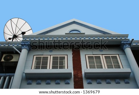 Blue stone house with satellite dish on the roof
