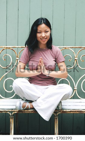 Fresh faced young Korean woman with hands together in prayer pose