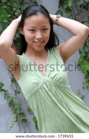Pretty Korean woman with her arms behind her head