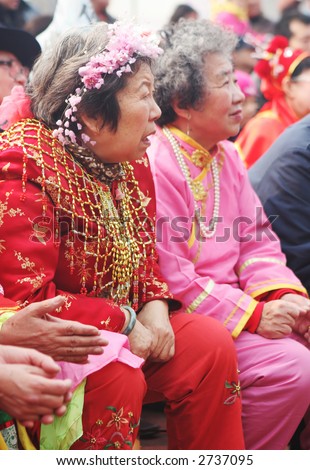 Chinese New Year celebrations in Qingdao, China - elderly Chinese women watch a performance during a festival on the second day of the week-long vacation.