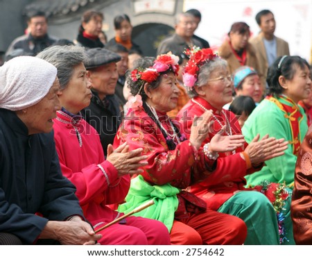 Chinese New Year celebrations in Qingdao, China - elderly Chinese women watch a performance during a festival on the second day of the week-long vacation.