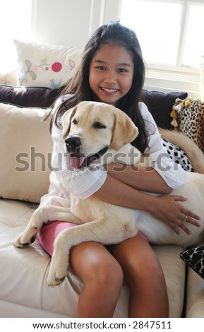 Happy Asian girl on animal print sofa with her pet dog