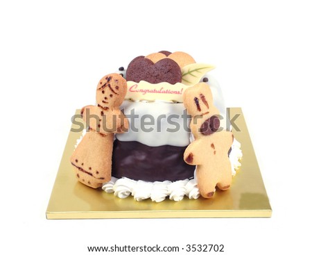 Chocolate cream cake isolated on white. Has cookies in the shapes of hearts, rabbit and a woman and a congratulations chocolate.