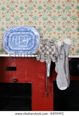 Socks and mittens hanging over a fireplace in a historical home.