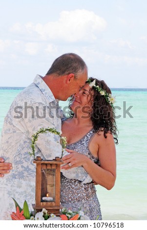 Bride and groom kissing on their tropical beach destination wedding day.