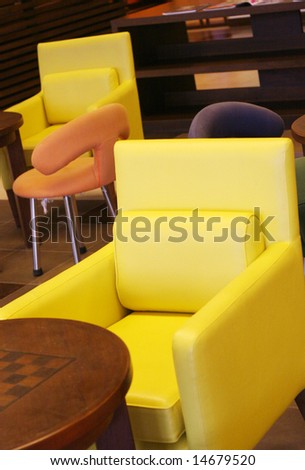 Colorful furniture including a yellow chair and wooden table.