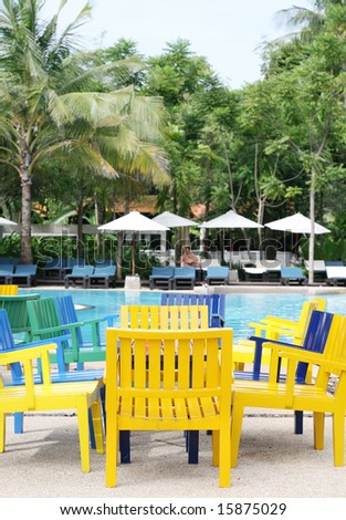 Colorful furniture next to a swimming pool.