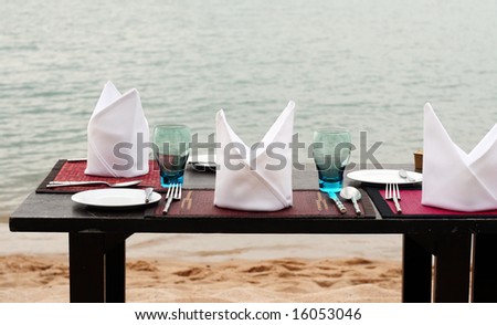 Romantic table setting on a sandy beach.