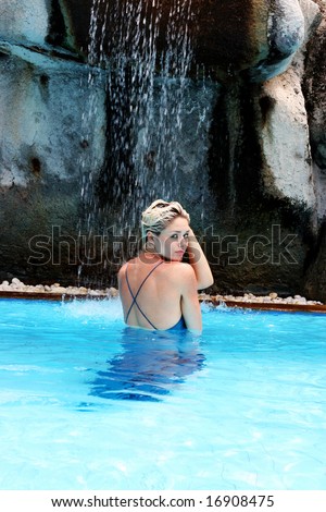 Woman wearing an evening dress in the pool during a trash the dress session.