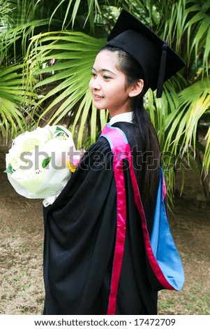 Beautiful young Asian graduate in robes on graduation day.