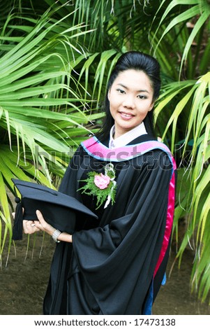 Beautiful young Asian graduate in robes on graduation day.