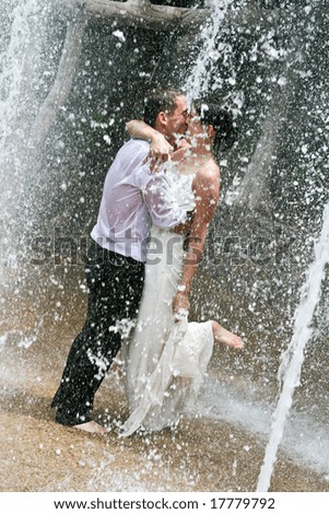 Bride and groom dancing under a water fountain on their wedding day.