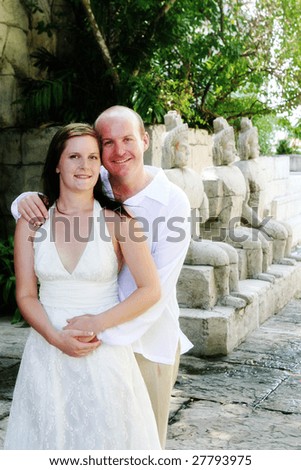 stock photo Gorgeous bride and groom standing next to Asian statues on 