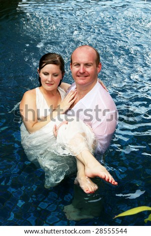 Gorgeous bride and groom in the water during a trash the dress photo shoot.