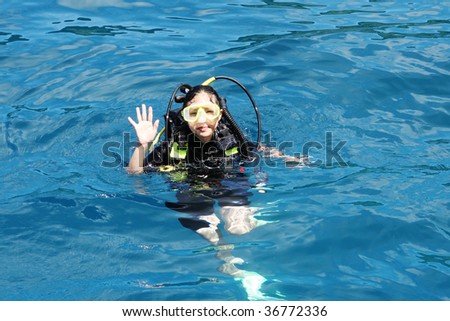 Female scuba diver in the blue ocean.