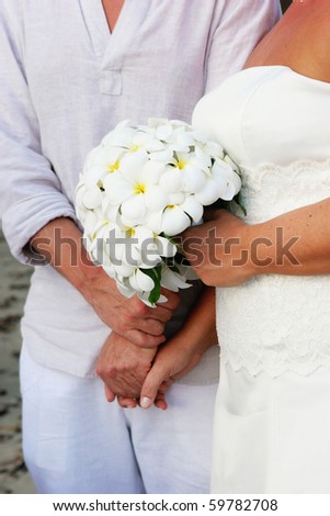 stock photo Closeup of a bride holding a frangipani wedding bouquet at 
