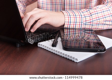 Typing text on laptop, tablet,  paper notebook and pen.