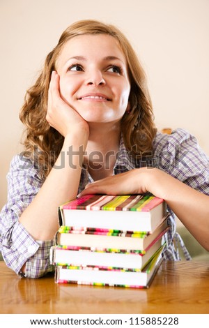 Attractive female student with books dreaming at university