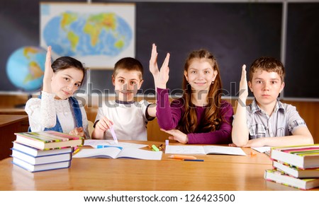 Four schoolchildren aged 11 at the desk in classroom
