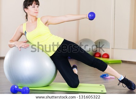 Pretty young woman fitness workout in gym with fitball