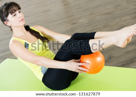 Pretty young girl fitness workout with small ball