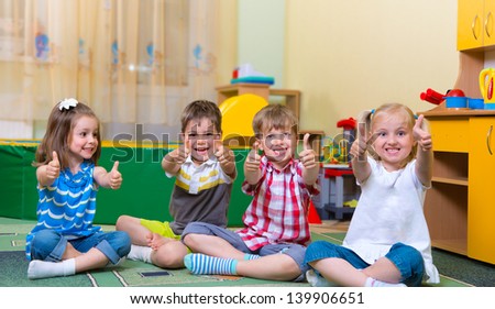 Group of excited children holding thumbs up