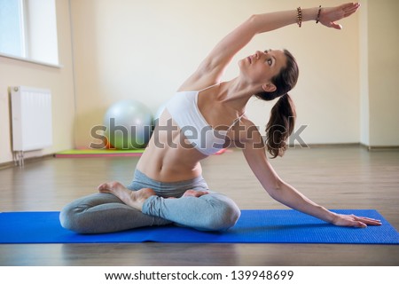 Young pretty female exercising in fitness club
