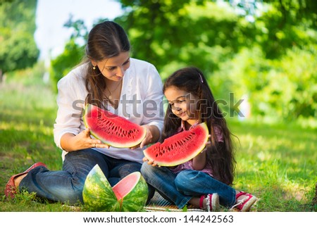 Happy Indian Family Eating Watermelon In Park