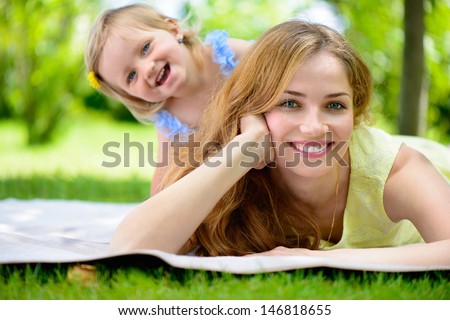 Happy Young Mother With Her Daughter At Park