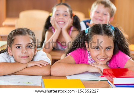 Happy schoolchildren during lesson in classroom at school