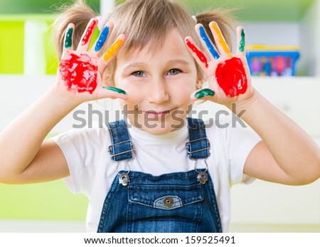 Portrait of happy little girl with colorful pains on hands