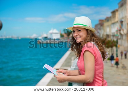 Happy young woman with tourist map in Venice