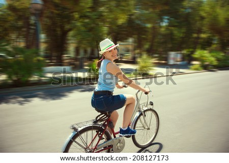 Happy young girl with bicycle in town