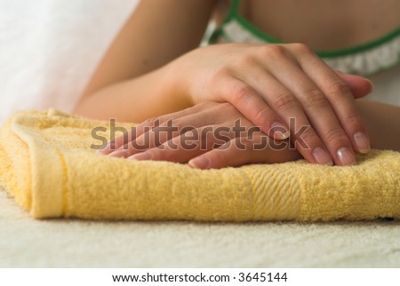 Nice hands on yellow towel. Soft manicure.