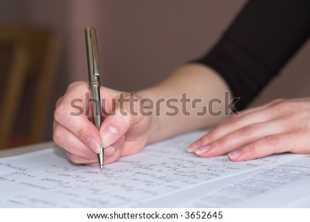 Female student is taking test in math. Fingers in focus.