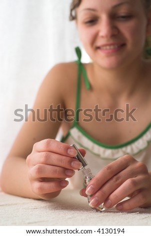 Young female is holding varnish in her hands and smiling